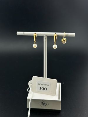 a close up of a pair of earrings on a stand