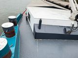 a boat that is sitting on the water with a bridge in the background