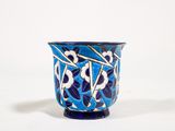 un vase bleu et blanc posé sur une surface blanche