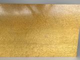 a close up of a piece of gold paper on a table