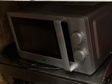 a microwave sitting on top of a metal shelf