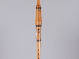 a close up of a wooden flute on a clear surface