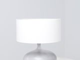 une image représentant une lampe de table blanche posée sur une surface blanche