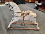a wooden rocking horse that is sitting on the floor