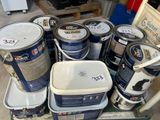 de nombreux pots de peinture posés sur un chariot dans le garage