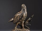 une statue en bronze représentant un aigle perché sur une branche d'arbre