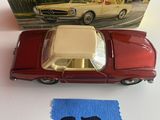 une petite voiture posée à côté d'un tissu bleu