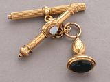 a gold keychain with a black and white charm on it