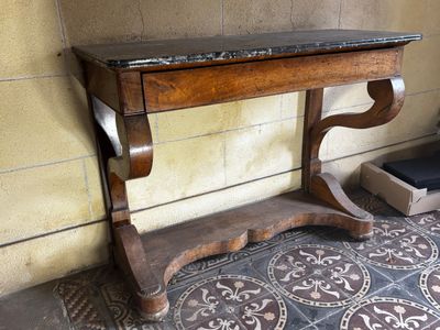 une table en bois avec un plateau en marbre posée sur un sol carrelé