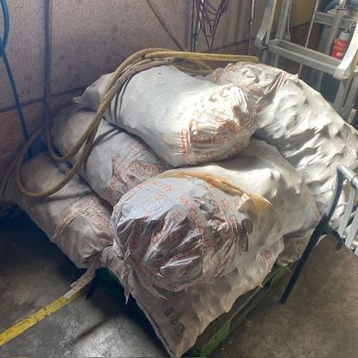 des sacs de ciment posés sur une charrette dans un garage