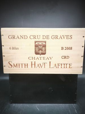 une caisse en bois sur laquelle est accrochée une pancarte indiquant « grand crude graves »