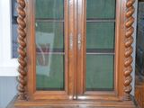 a wooden cabinet with a glass door on top of it