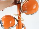 a person holding an orange lamp that is attached to a pole