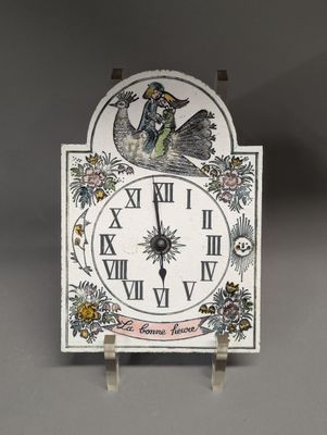 a clock with a bird on it on a stand