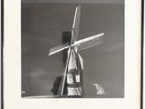photographie en noir et blanc d'un moulin à vent au milieu d'un champ