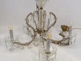 un lustre en cristal avec des bougies posées sur une table blanche