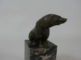 statue of a dog sitting on a marble block on a white background