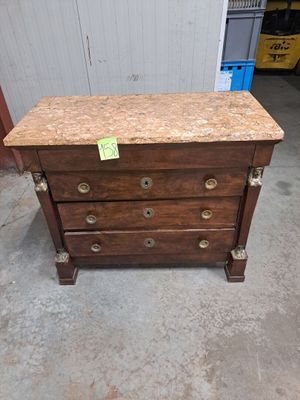 une commode en bois avec un plateau en marbre, dans un garage