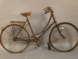 a old bicycle that is leaning up against a wall