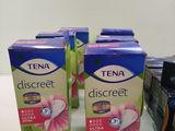 three boxes of tena discreet on a table next to a box of toilet paper