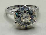 a close up of a diamond ring on a white surface
