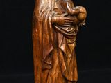 wooden statue of a woman holding a child in her arms
