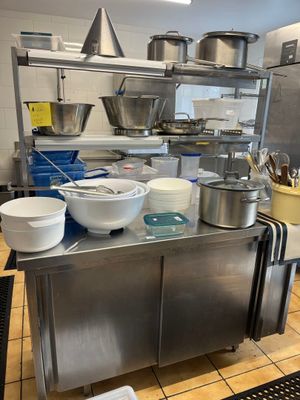 de nombreux bols et casseroles sur le plan de travail de la cuisine
