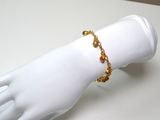 a white mannequin hand with a gold bracelet on it