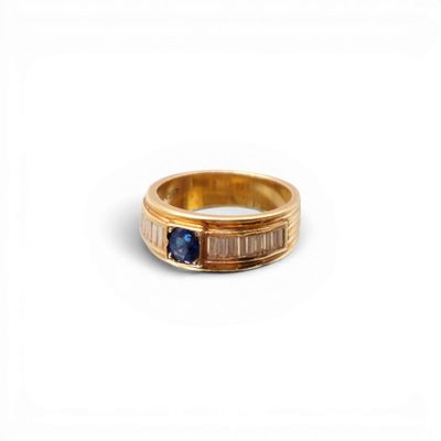 gros plan d'une bague en or avec une pierre en saphir