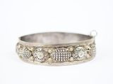 un gros plan d'un bracelet en argent serti de diamants sur fond blanc