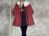 a wooden doll that is standing next to a measuring tape