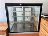 a glass display case with a clock inside of it