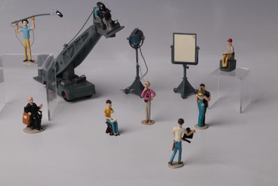 de nombreuses figurines représentant des personnes debout devant un appareil photo