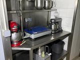 a kitchen with a stainless steel shelf and a mixer on the counter