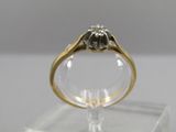 un gros plan d'une bague en diamant posée sur un socle transparent
