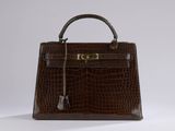 a brown crocodile skin handbag with gold hardware and handle