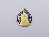 a close up of a gold pendant with a blue and white design