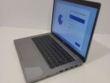 a laptop computer sitting on a white table with a blue screen