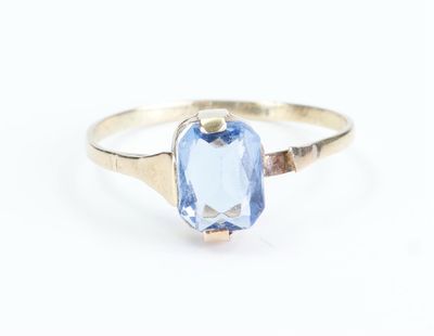 a close up of a ring with a blue stone in it