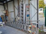 une échelle appuyée contre un mur, à côté d'un tas de vieilleries