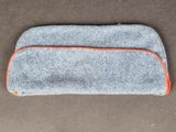 un gros plan d'un étui gris et orange posé sur une surface marron