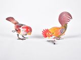deux figurines de coqs placées l'une à côté de l'autre