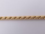 a close up of a gold chain on a white surface