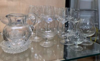 des bouteilles et des verres posés sur une étagère en verre dans une pièce