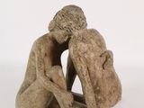 statue of a man and a woman sitting on a white surface