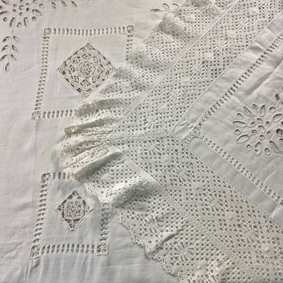 un gros plan sur une nappe blanche ornée de motifs au crochet