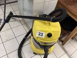 un sèche-linge jaune posé par terre dans une cuisine