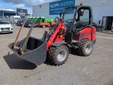 a picture of a red tractor parked in front of a building