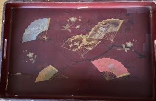 a red tray with oriental designs on it sitting on a table