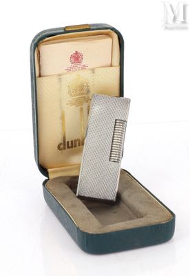 un briquet en argent posé dans un étui sur une surface blanche